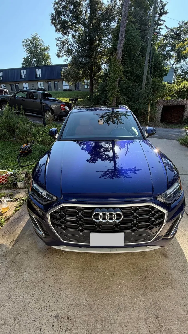 Blue Audi SUV after exterior wash and detail in the customer driveway